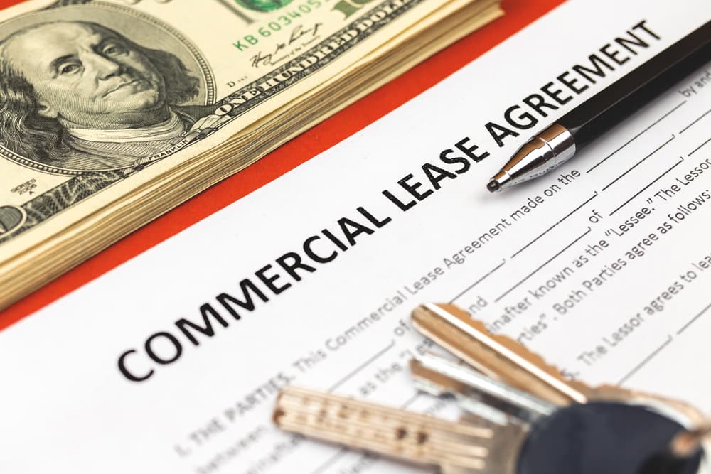 Commercial Lease Agreement Form, Pen, and Money on an Office Desk.