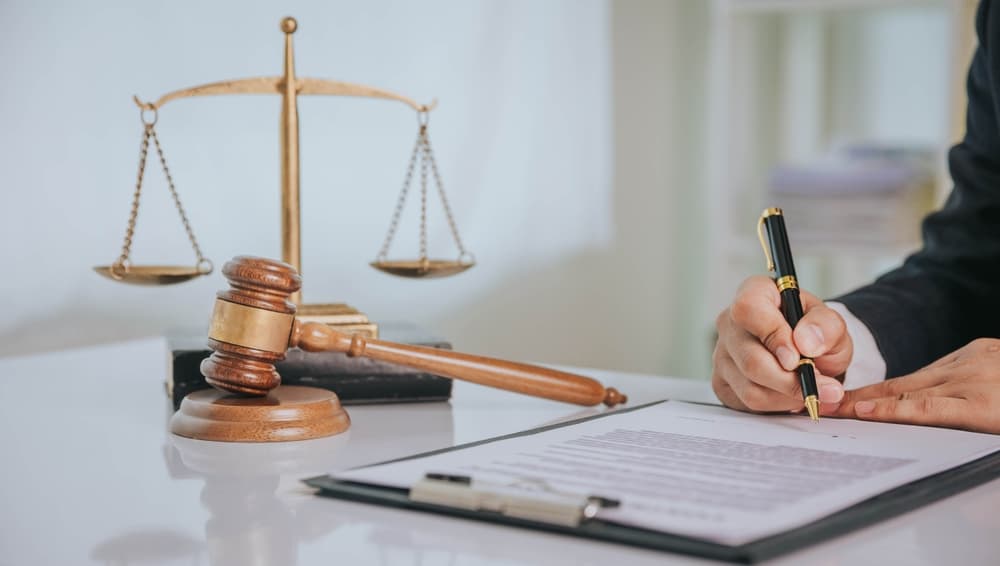 Judge's gavel with legal team in the background, representing concepts of justice and law at a law firm.