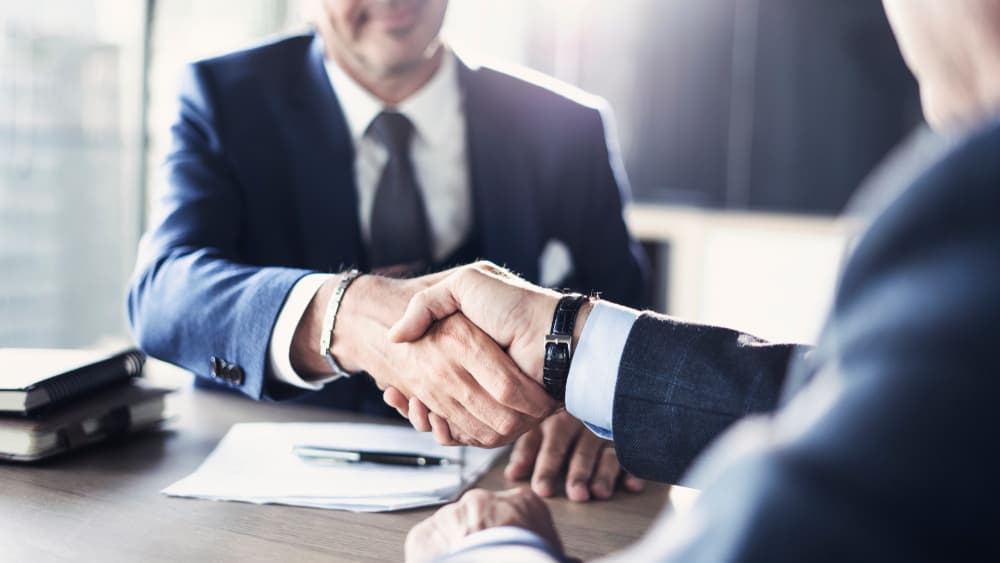 Professional business meeting in an office setting, showing two business partners engaged in discussion, symbolizing collaboration and partnership