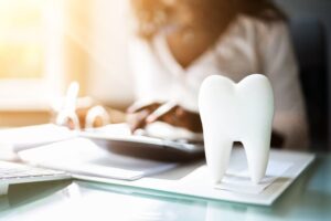 Dental insurance concept featuring a dentist service desk with dental implants and money, symbolizing financial aspects and coverage of dental procedures.