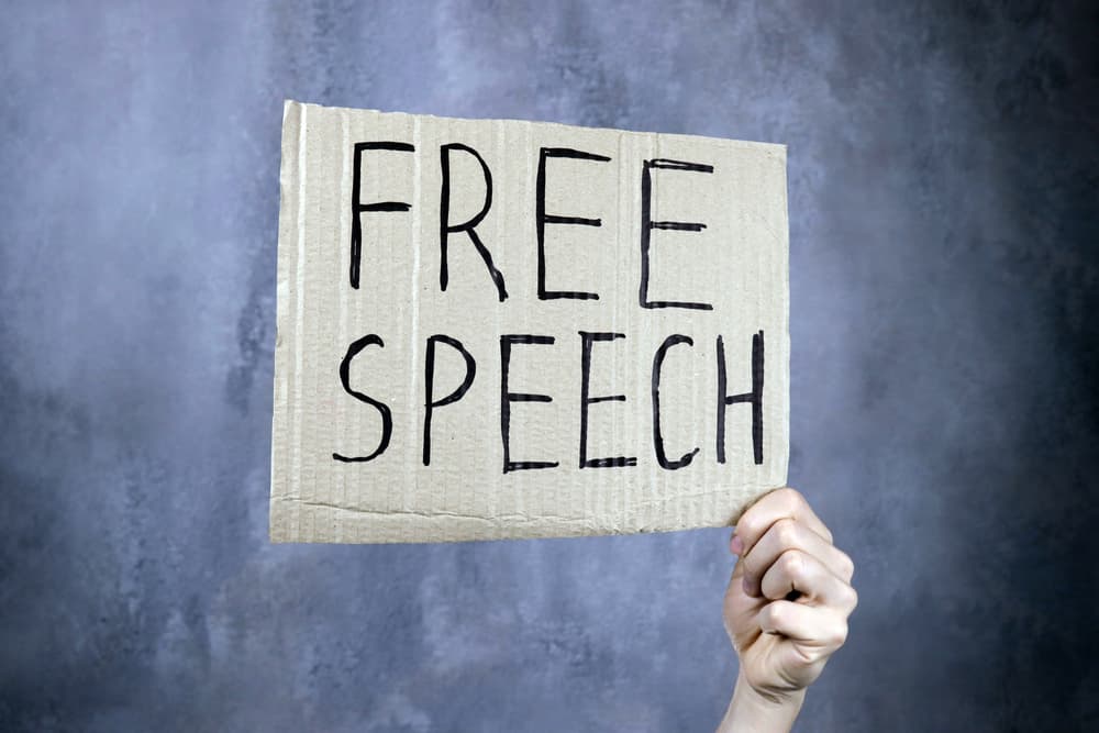 hand holds a banner with the inscription free speech, censorship concept