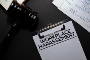 Workplace Harassement text on Document and gavel isolated on office desk.
