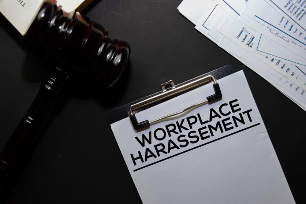 Workplace Harassement text on Document and gavel isolated on office desk.