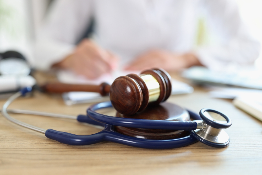 Close-up of a gavel and stethoscope symbolizing legal disputes in healthcare and dental practices.