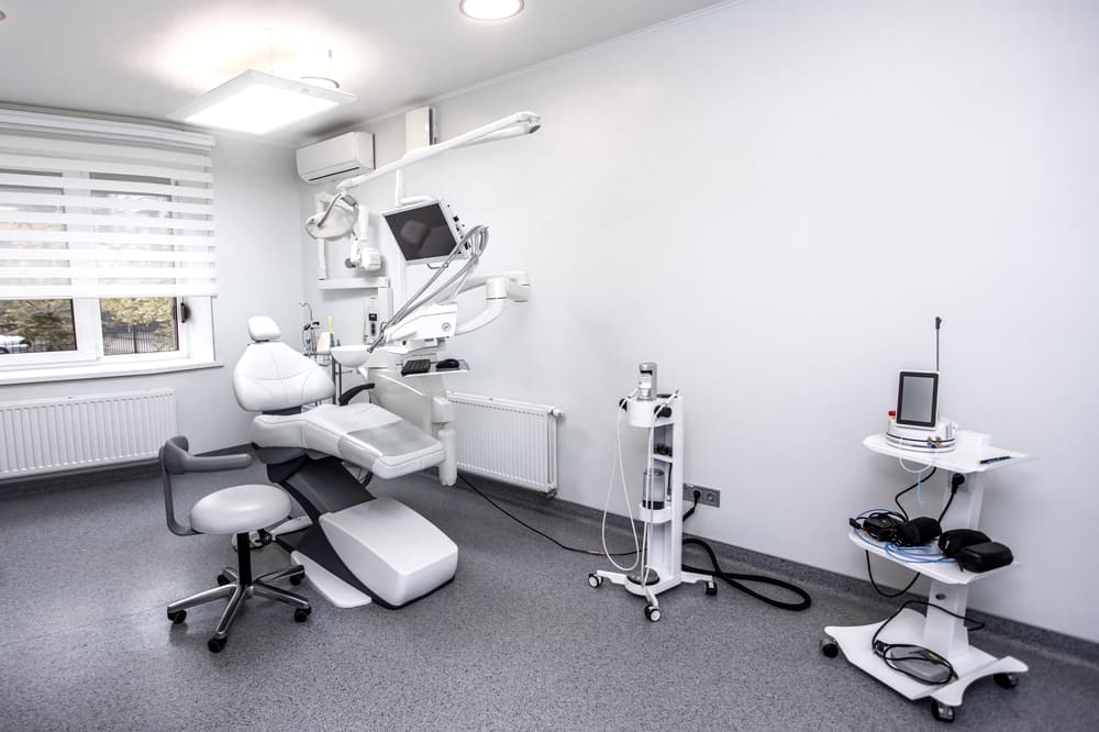 Modern dental treatment room with exam chair and equipment, representing a typical office setup for real estate ownership considerations