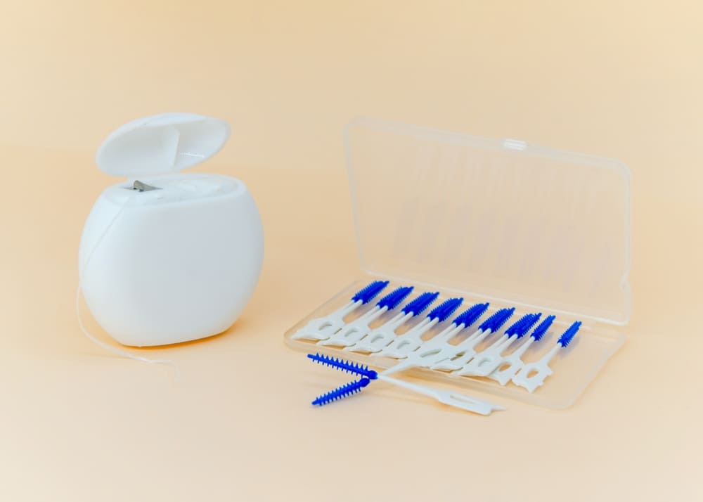 Dental floss container and interdental brushes on a counter, showing common supplies found in a dental practice